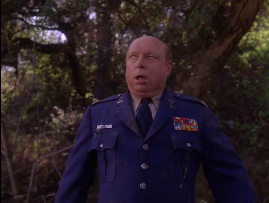 Major Briggs stumbling toward the road in Episode 2021.