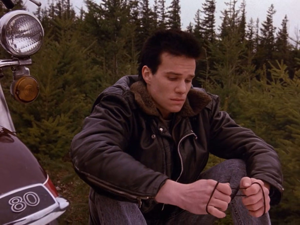 James Hurley holding Laura Palmer's necklace on a mountain overlook