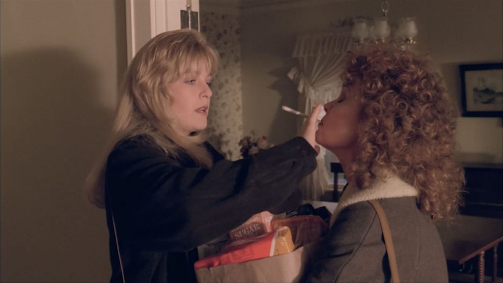 Laura Palmer helps her mother Sarah with her cigarette