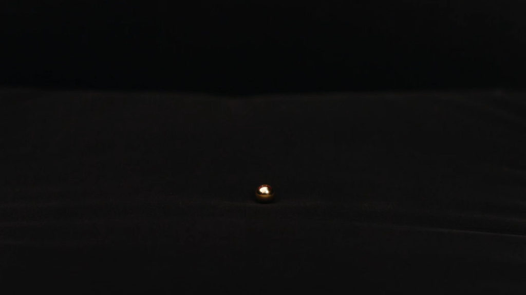 Golden Metal Ball in the empty Red Room Chair